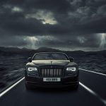 Image of a sleek black car being driven through a storm